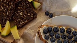 A vibrant spread of seeded bread, blueberries, and honey. Perfect for breakfast.